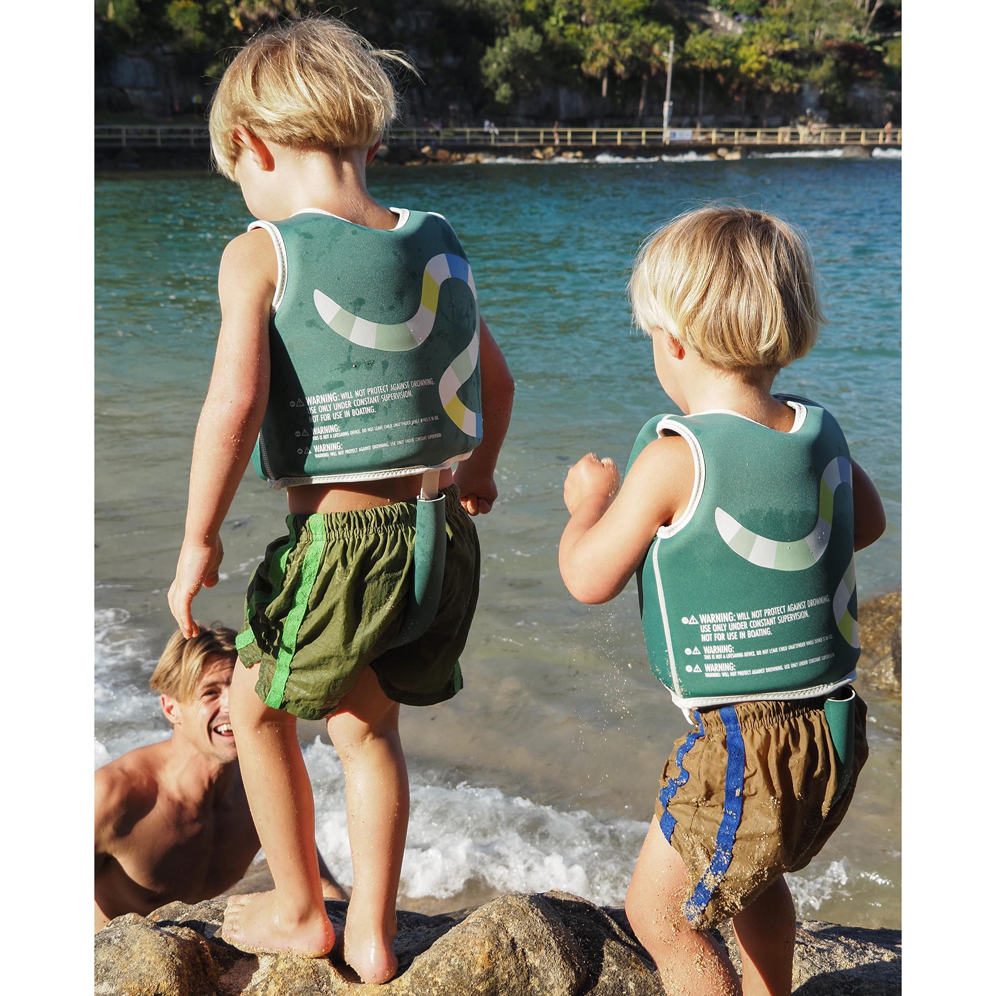 Sunnylife Into The Jungle Float Vest in green, worn by child at beach