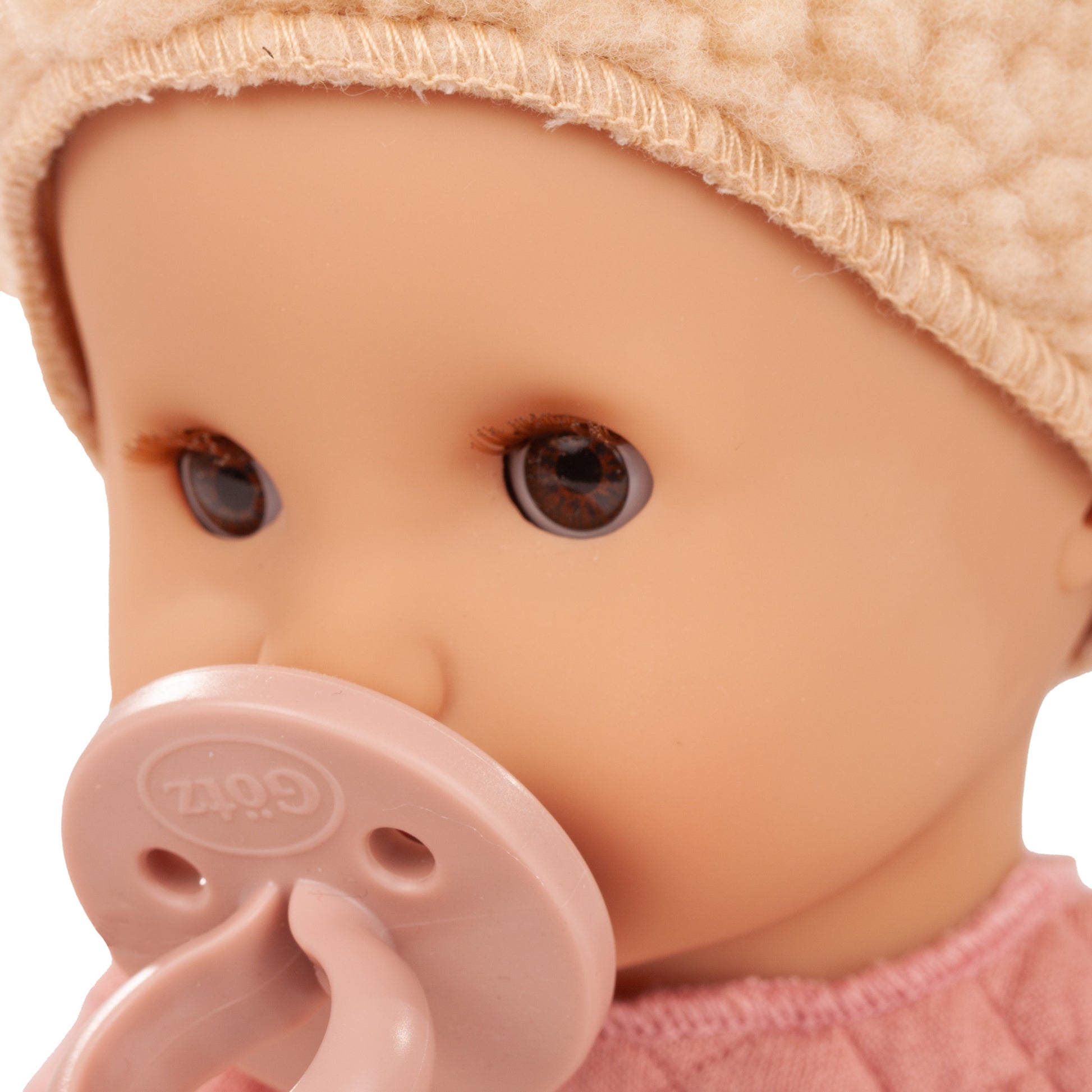Gotz Sleepy Aquini 13" baby doll with brown eyes, pink pacifier, and cream hat
