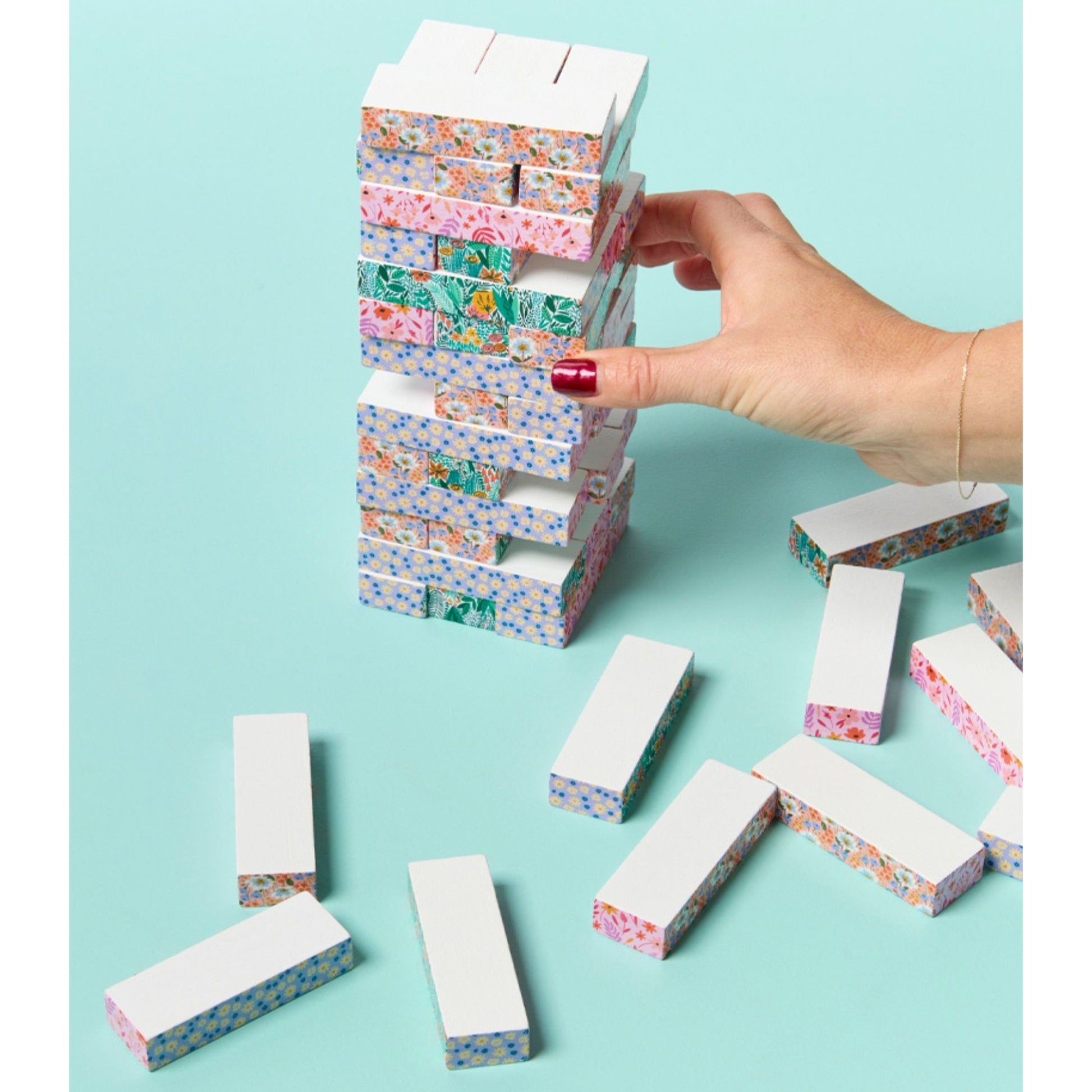 JOS Tumbling Tower wooden block game with colorful floral patterns in pink, blue, and green