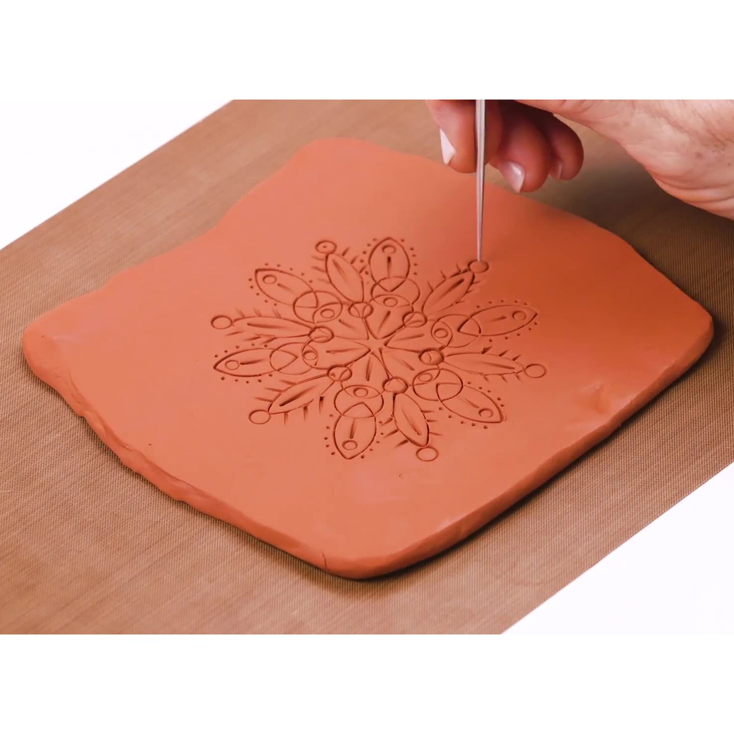 Original Sculpey Terra Cotta clay with mandala pattern design being carved with tool
