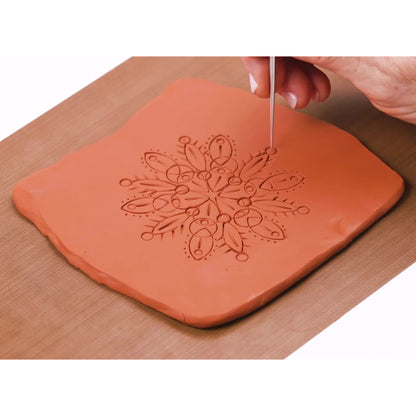 Original Sculpey Terra Cotta clay with mandala pattern design being carved with tool
