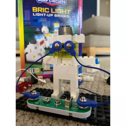 Snap Circuits BRIC Light educational toy with illuminated white brick figure and blue electronic components