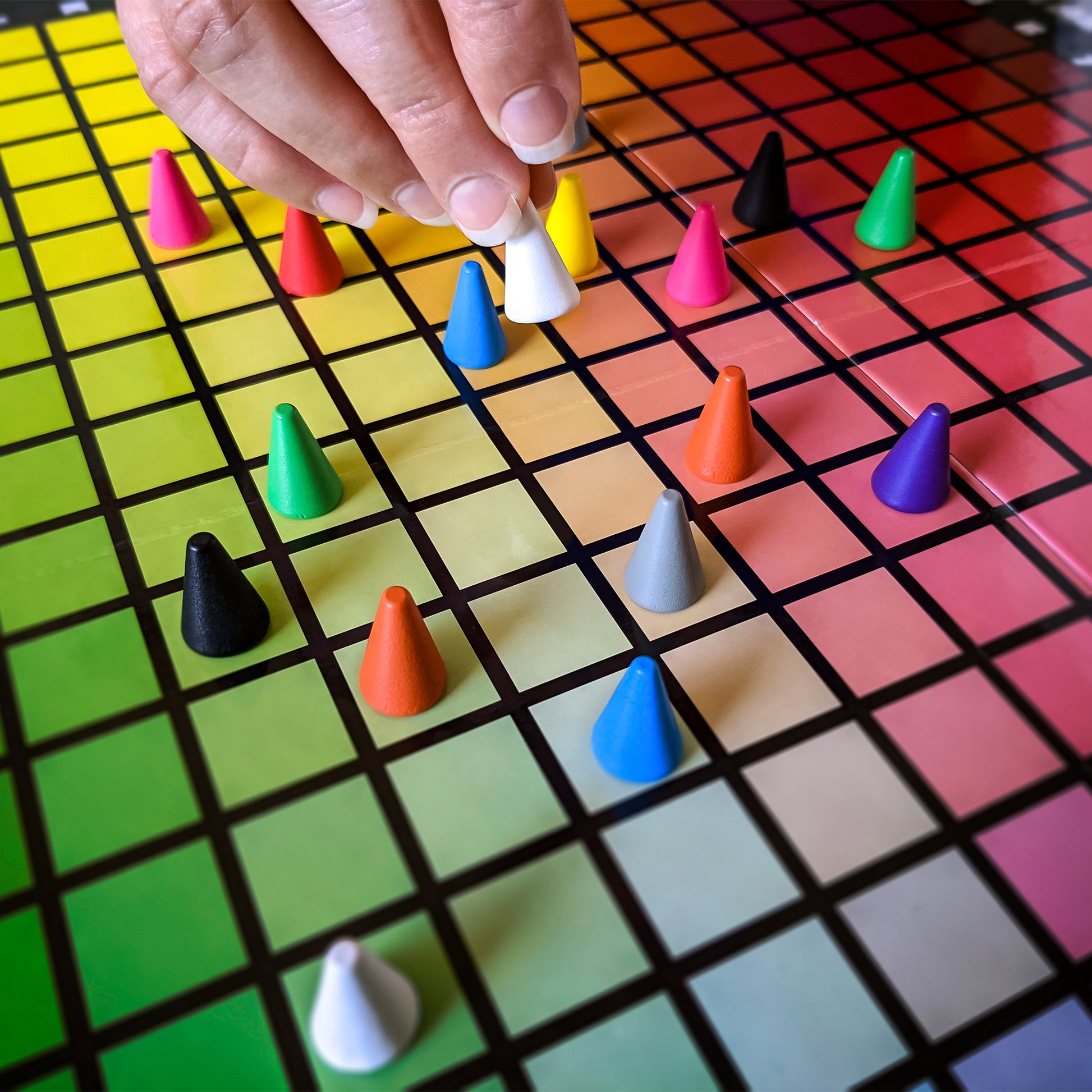 Hues & Cues color guessing game with colorful cone pieces on rainbow grid board