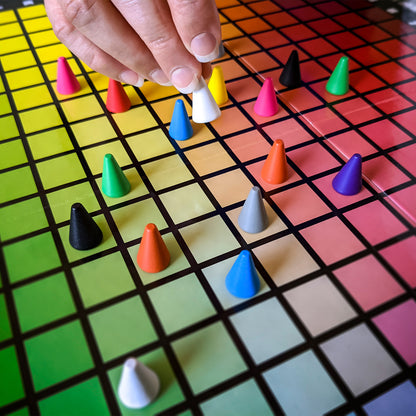 Hues & Cues color guessing game with colorful cone pieces on rainbow grid board