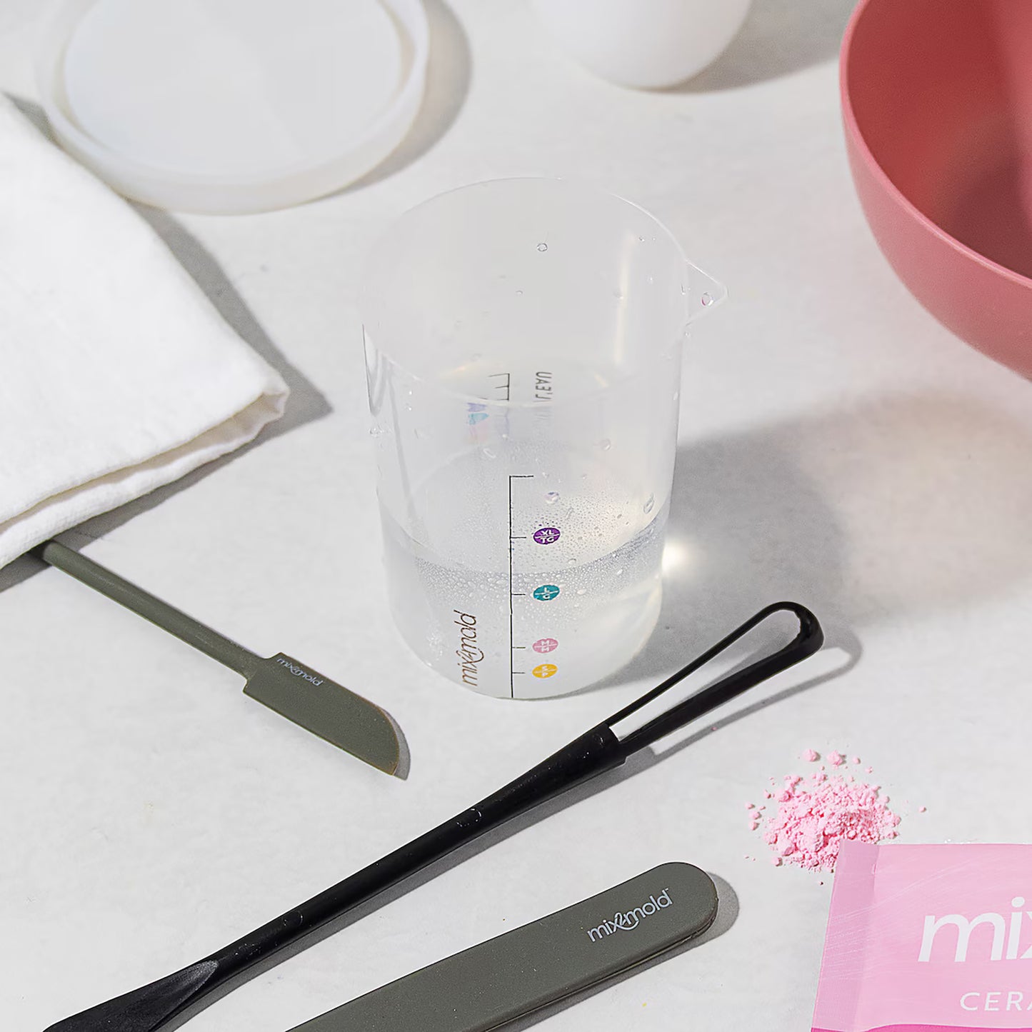 Mix2Mold Ceramic Resin Tool Set with measuring cup, mixing tools, and pink powder