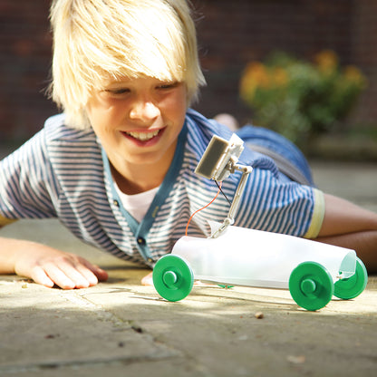4M Green Science Solar Rover DIY kit with green wheels, child playing outdoors