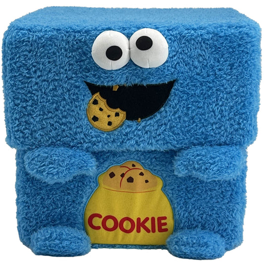 Blue plush storage cube with Cookie Monster face, large white eyes with black pupils, black smile holding a chocolate chip cookie, yellow cookie jar labeled COO