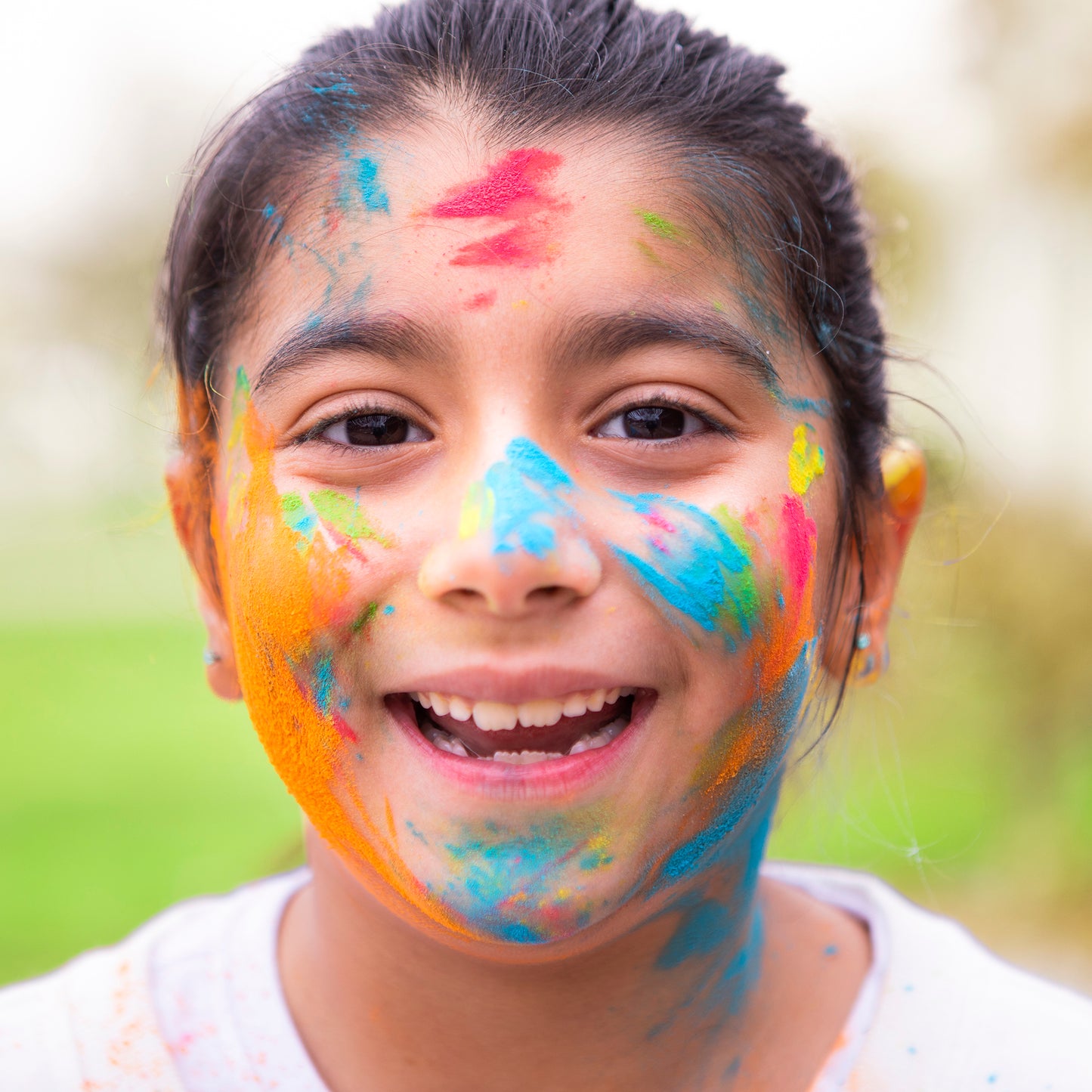 Holi Color Powder 7-pack demonstrating vibrant blue, pink, orange, and green powder colors on child's face