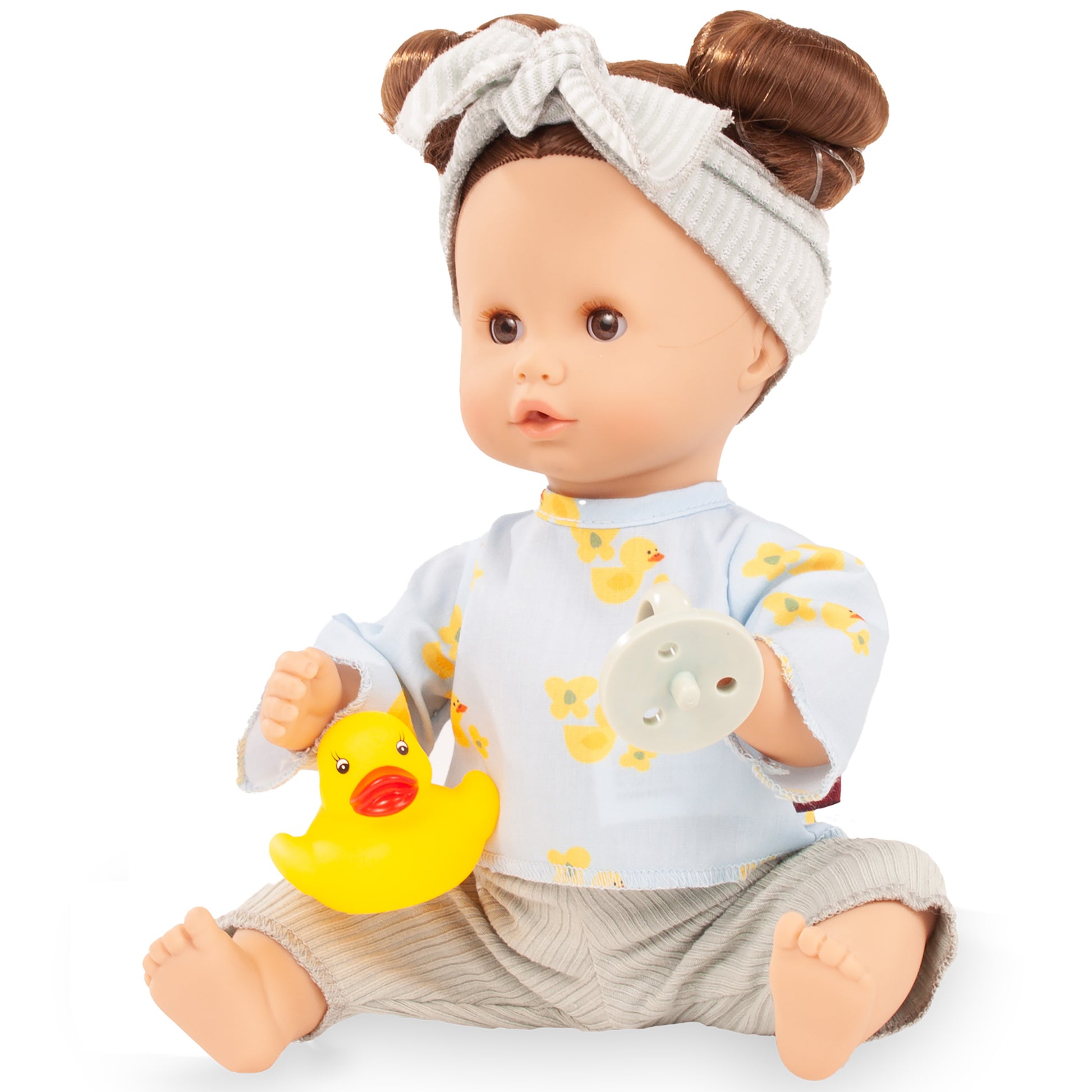 Gotz Sleepy Aquini 13 inch baby doll with brown hair buns, white headband, duck print outfit, holding yellow duck toy