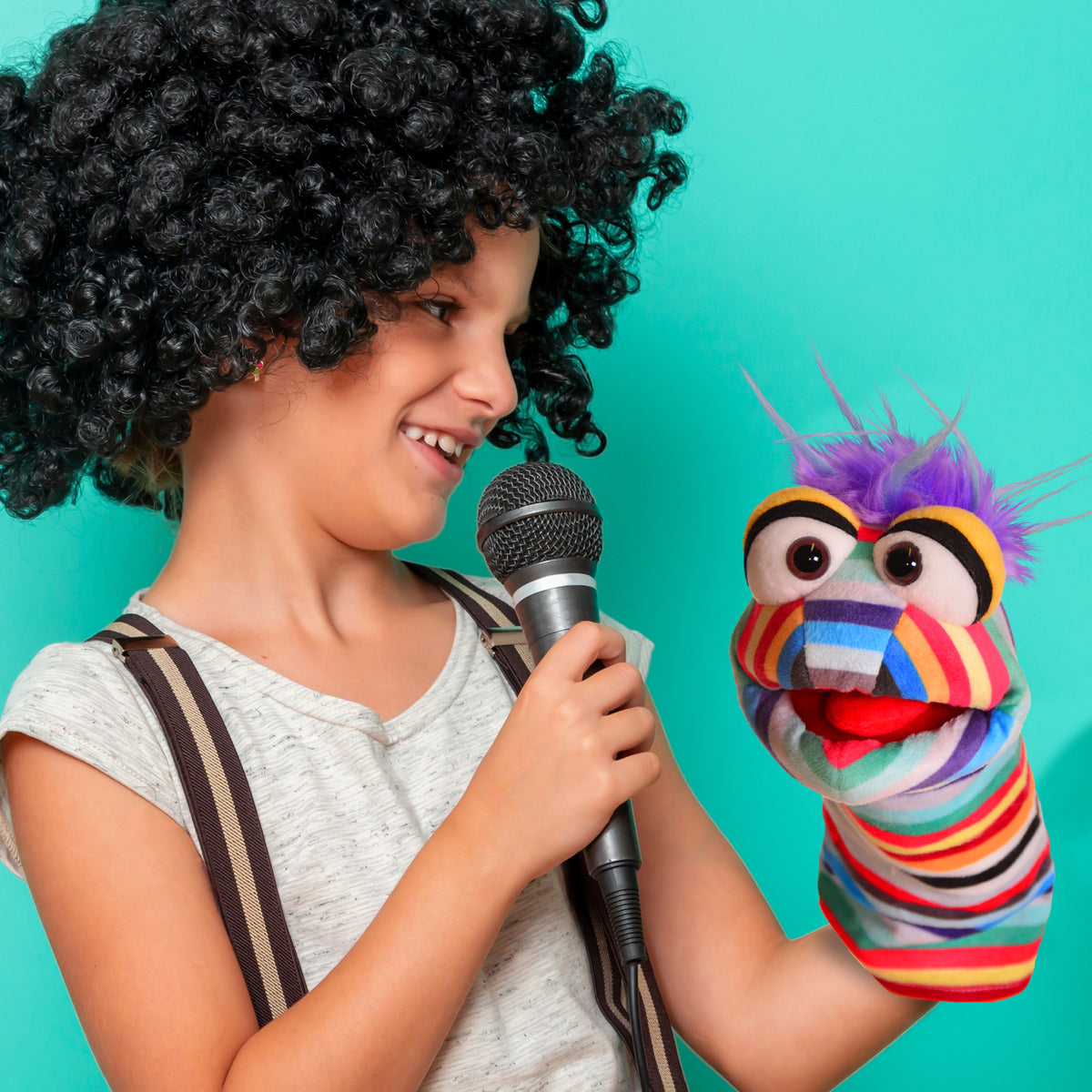 Living Puppets Pocky Sock hand puppet with colorful striped body and purple spiky hair, shown with child holding micr...