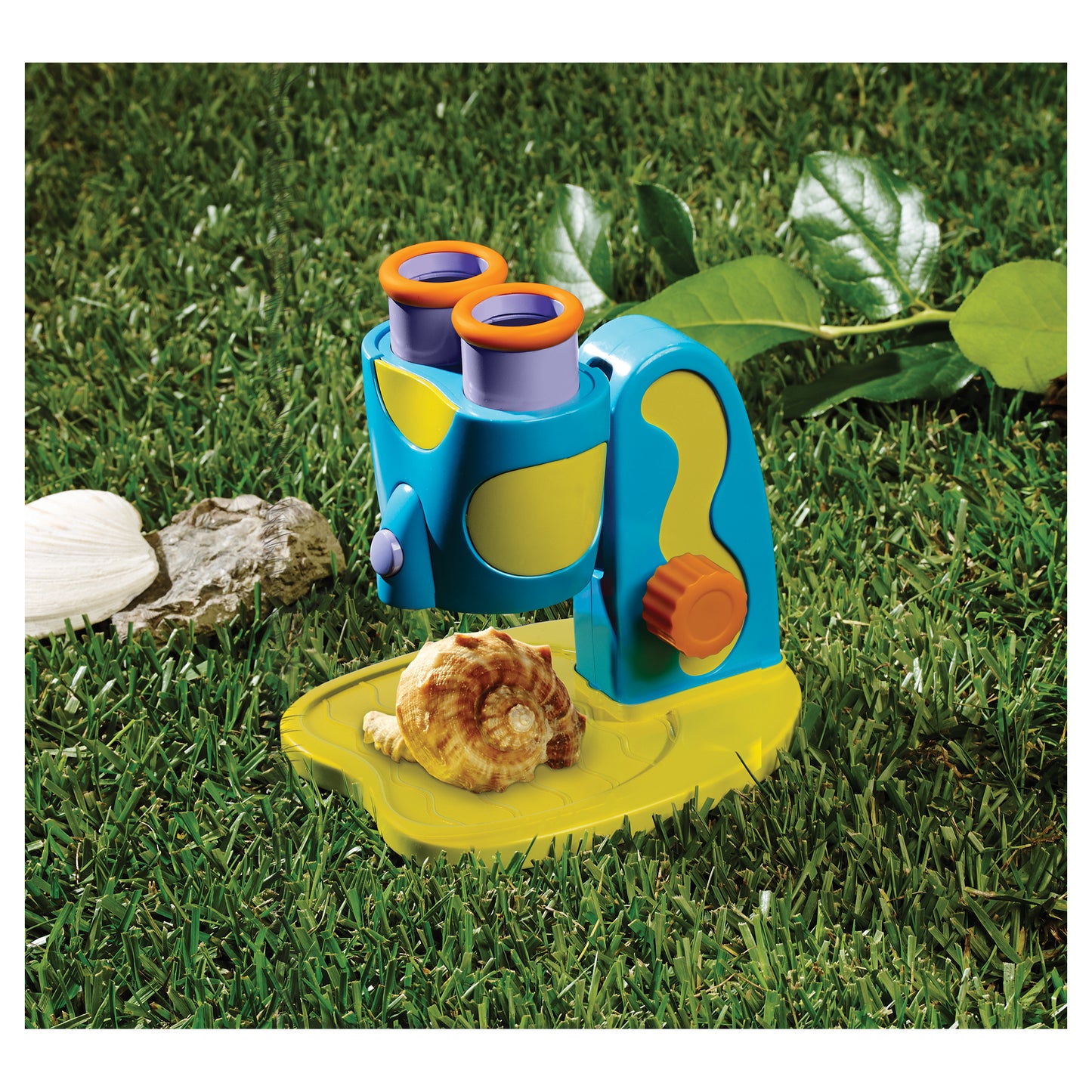 GeoSafari Jr. My First Microscope in blue and yellow with orange eyepieces on grass