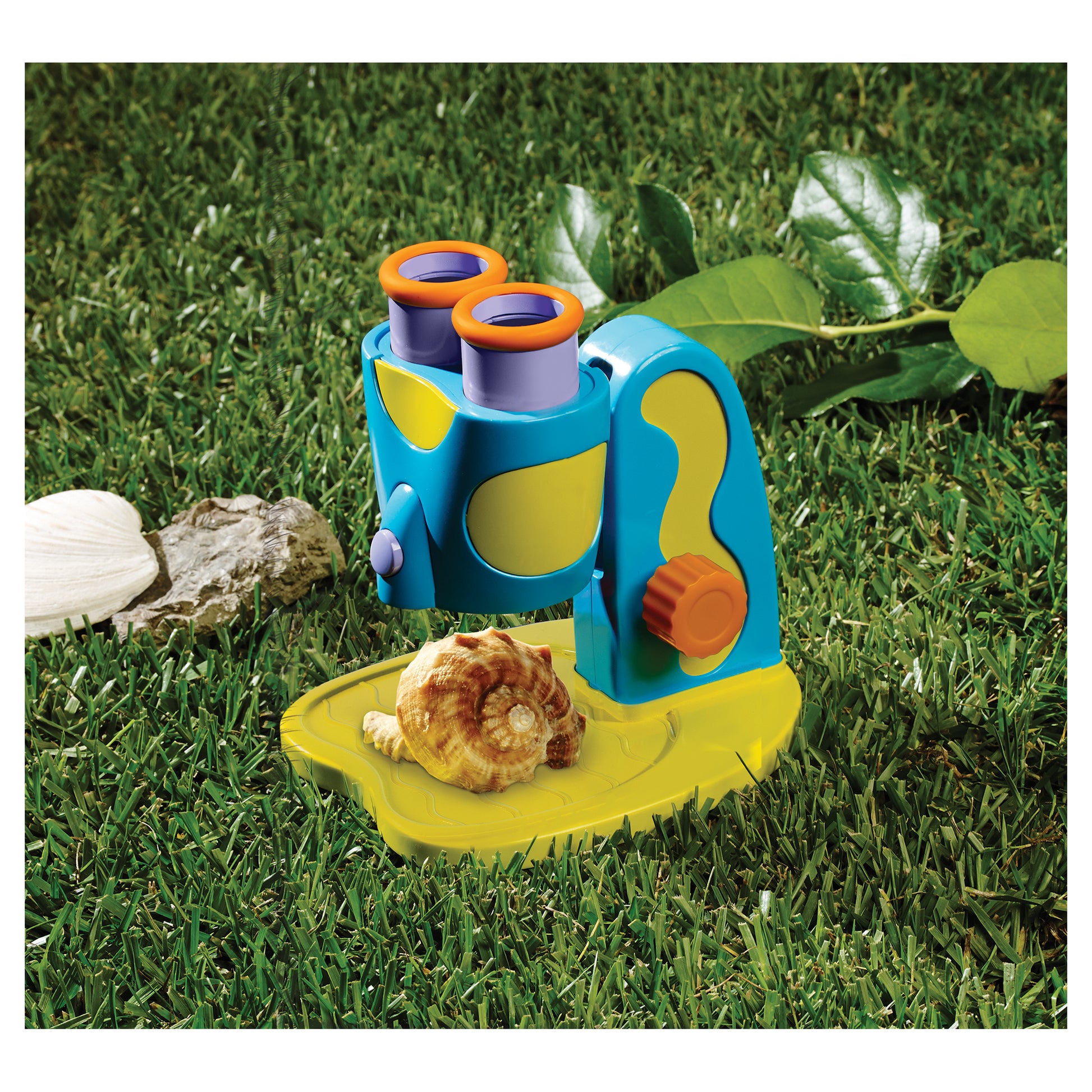 GeoSafari Jr. My First Microscope in blue and yellow with orange eyepieces on grass