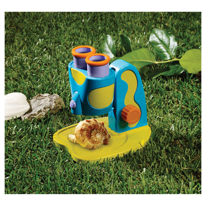 GeoSafari Jr. My First Microscope in blue and yellow with orange eyepieces on grass