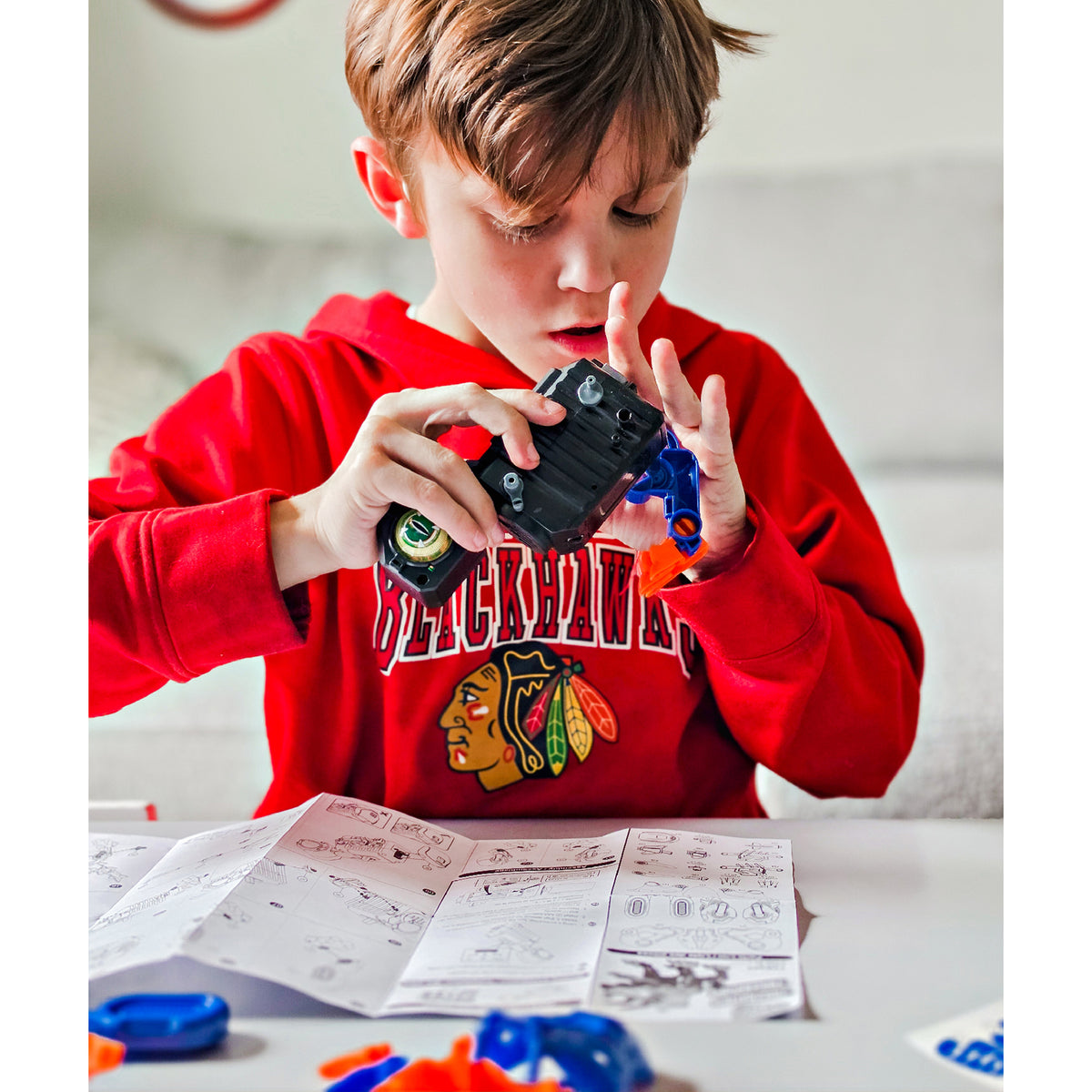 Child building Teach Tech Triceratops Robot STEM toy with instruction manual