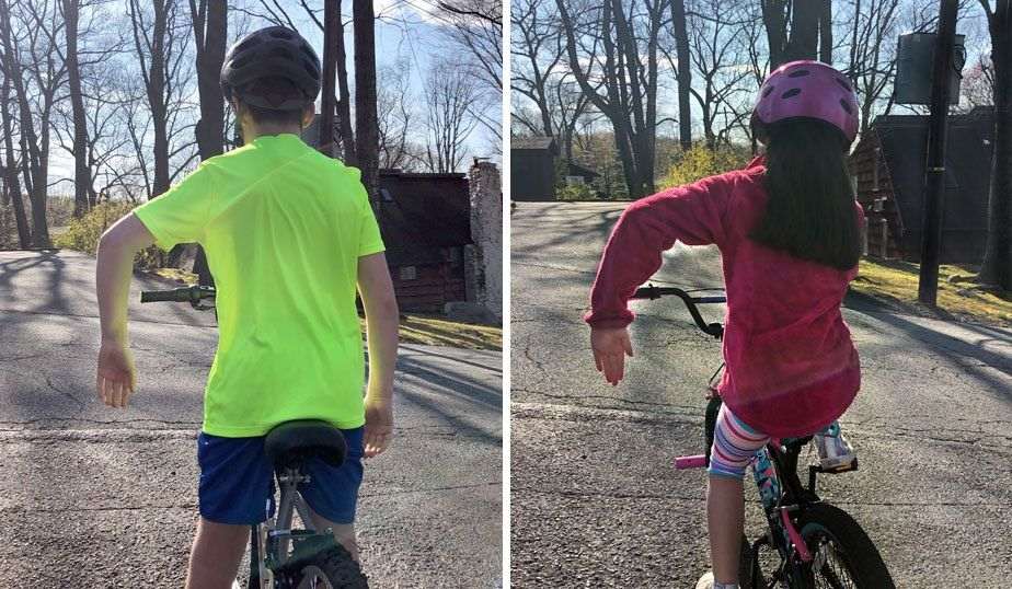 boy and girl using the STOP hand signal on their bikes