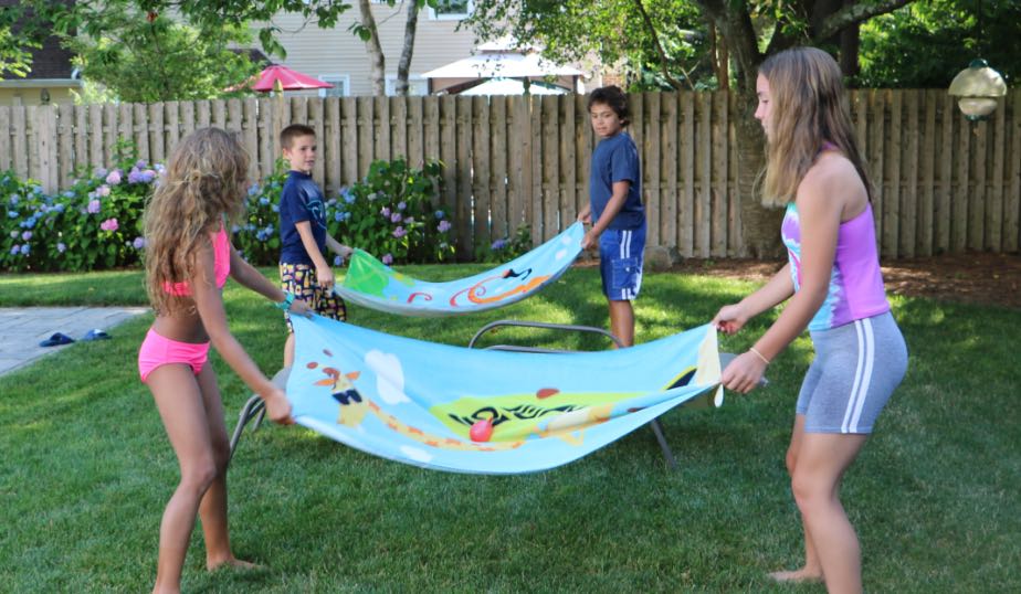 young children getting ready to toss the water balloons in an outdoor game for kids
